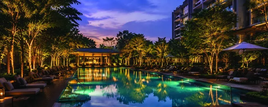 Swimming pool at dusk with a cabana and loungers